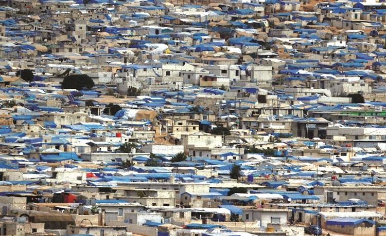 صورة عامة من مدينة الريحانية التركية لبلدة اطمة التي تحوي احد اكبر مخيمات اللاجئين في ادلب- (رويترز) ﻿