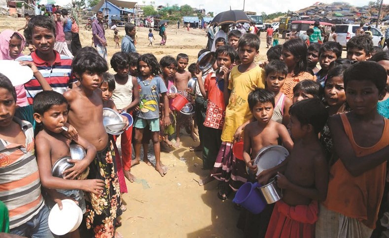 اطفال لاجئي الروهينغا يتجمعون بانتظار توزيع المساعدات عليهم في بنغلاديش	(ا.ف.پ)﻿