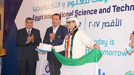 الطالب حسين جرخي رافعاً علم الكويت لدى اعلان فوزه بالمركز الثالث 