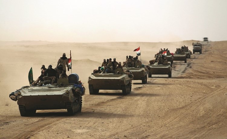  القوات العراقية وعناصر من الحشد الشعبي خلال تقدمها باتجاه مدينة القائم	-(أ.ف.پ)﻿