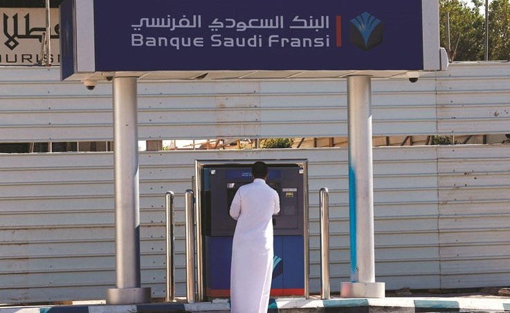 سعودي يسحب نقدا من احدى ماكينات السحب الآلي في الرياض امس	 ( رويترز) ﻿