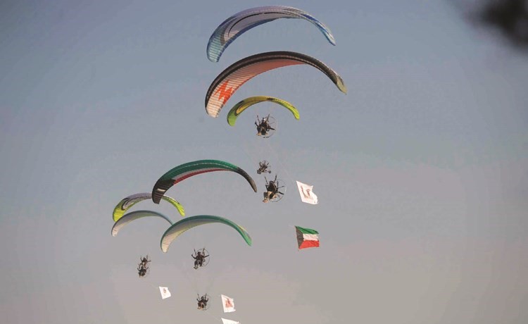 الطائرات الشراعية تحمل علم الكويت وصورتي صاحب السمو الأمير الشيخ صباح الأحمد وسمو ولي العهد الشيخ نواف الأحمد وعلم النادي العلمي ﻿