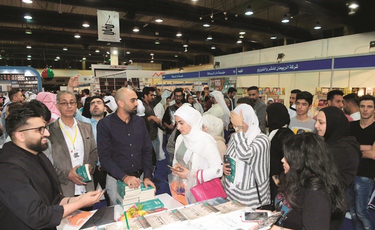 علي نجم مع مجموعة من الحضور خلال توقيع كتابه بمعرض الكتاب  ﻿