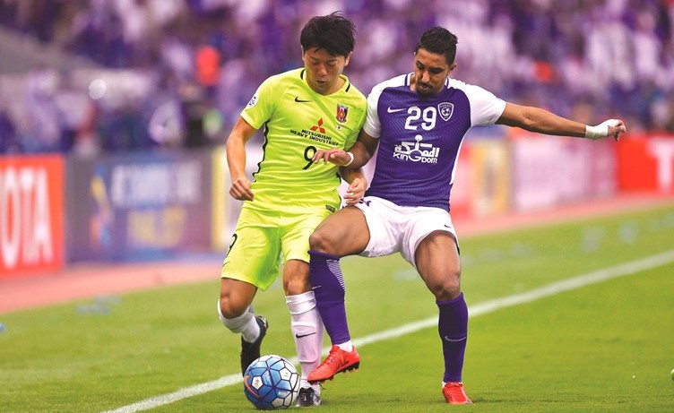 لاعب الهلال سالم الدوسري في صراع على الكرة مع اللاعب الياباني	 (أ.پ)﻿