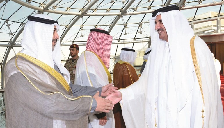 الشيخ محمد العبدالله مصافحا أمير قطر لدى وصوله إلى البلاد﻿