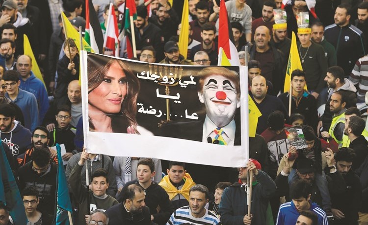 متظاهرون في الضاحية يرفعون صورا ساخرة للرئيس الأميركي دونالد ترامب 	(رويترز)﻿