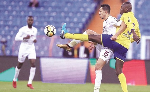 مدافع النصر عبدالله مادو يبعد الكرة من امام لاعب الفيصلي إسلام سراج ﻿
