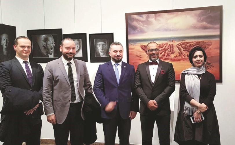 الرسامة مريم الملا وزوجها الرسام أسعد بوناشي مع مجموعة من زوار المعرض	﻿