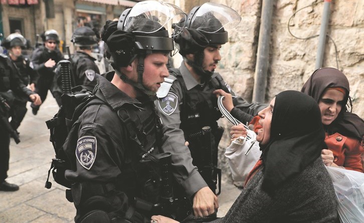 سيدة فلسطينية تعنف عناصر من قوات الاحتلال في البلدة القديمة بالقدس امس	(ا.ف.ب)﻿