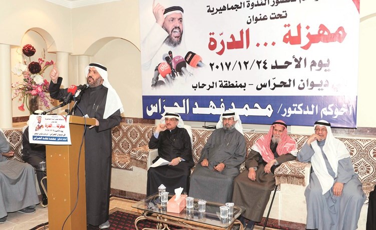 محمد فهد الحراس متحدثا ويبدو كامل العوضي وعدد من المشاركين في الندوة﻿