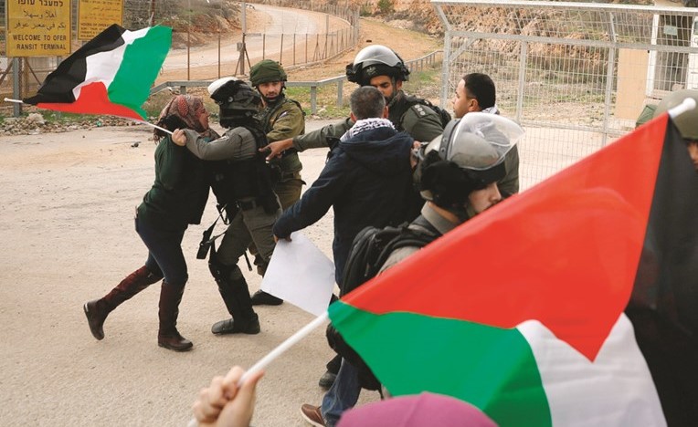 سيدة فلسطينية تقاوم قوات الاحتلال خلال مسيرة داعمة للطفلة المعتقلة عهد التميمي قرب سجن عوفر امس	 ( رويترز) ﻿