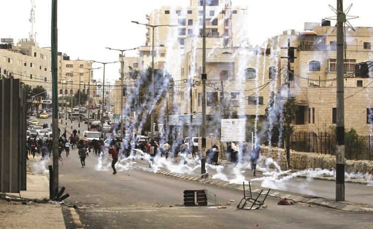 دخان القنابل المسيلة للدموع يتصاعد خلال مواجهات بين الفلسطينيين وقوات الاحتلال في بيت لحم امس	(ا.ف.پ)﻿