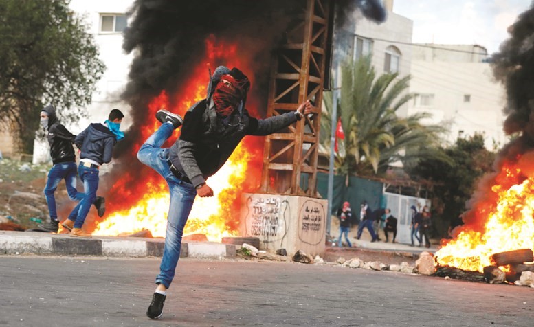 فلسطيني يلقي الحجارة على قوات الاحتلال خلال مواجهات قرب نابلس امس الاول          ( رويترز) ﻿