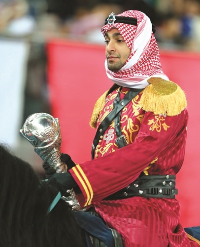 أحد فرسان فرقة الخيالة حاملا كأس الدورة	﻿