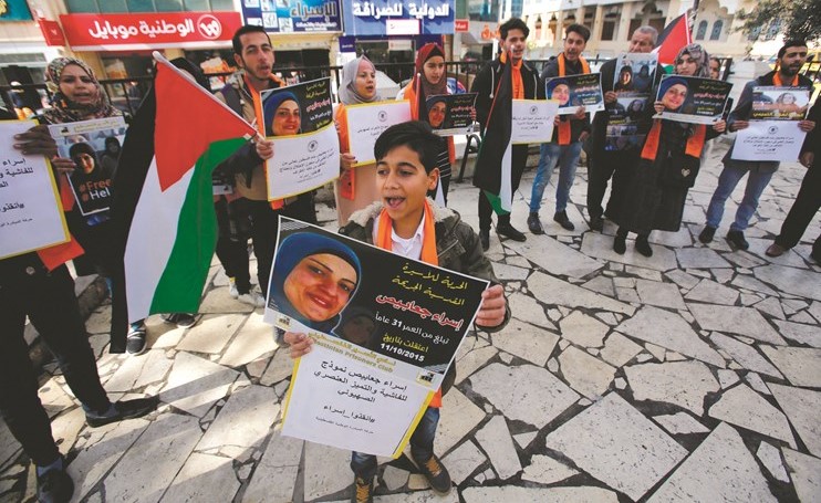 صبي فلسطيني يرفع صورة المعتقلة إسراء الجعابيص خلال تجمع يطالب الاحتلال بالإفراج عنها امس	(رويترز)﻿