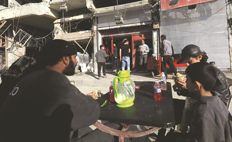 رقاويون يتناولون الفلافل أمام مطعم الملك الشهير وسطركام مدينة الرقة					(ا.ف.پ) ﻿