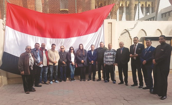 مجموعة من المصريين أمام السفارة أثناء متابعة عمل توكيلاتهم تتوسطهم المستشارة الإعلامية بالسفارة جمانة نجم﻿