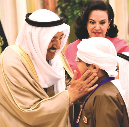 صاحب السمو الأمير مصافحا أحد المتفوقين من أبناء الشهداء﻿