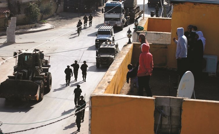 فلسطينيون يراقبون اقتحام قوات الاحتلال لإحدى قرى جنين امس	(أ.ف.پ)﻿