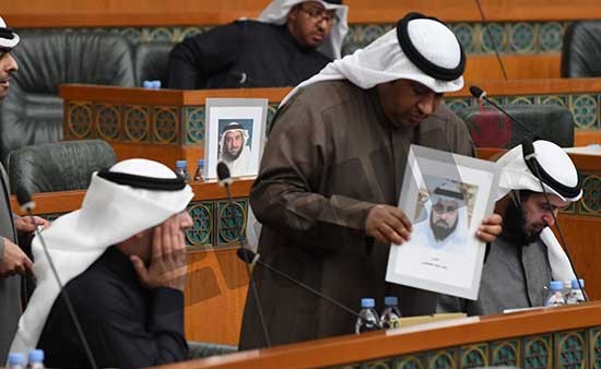 النائب الحميدي السبيعي يضع صورة النائب د.وليد الطبطبائي على مقعد الأخير داخل قاعة عبدالله السالم (هاني الشمري)