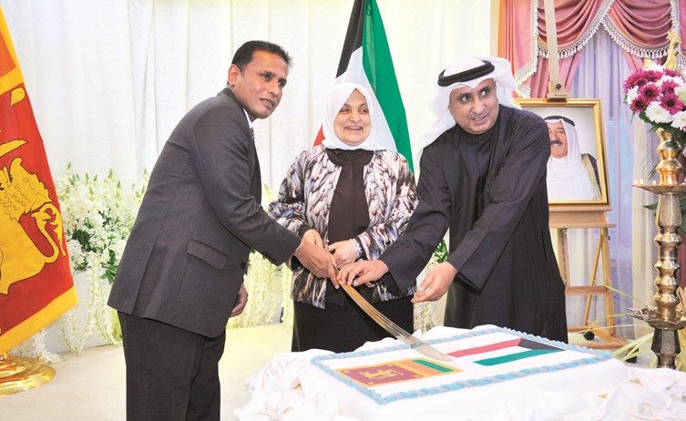 الوزيرة هند الصبيح والسفير السريلانكي كانديبان بالا وخلف بوظهير يقطعون كيكة الاحتفال ﻿