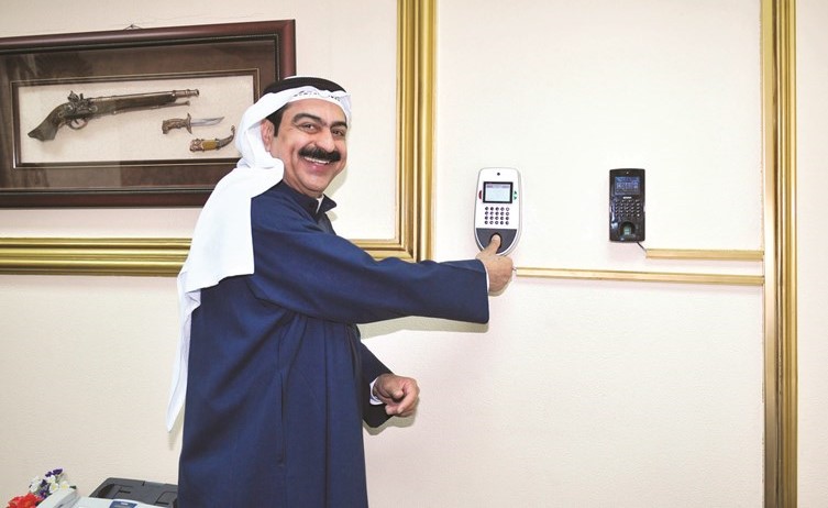 نجيب العوضي يبصم على أحد أجهزة البصمة في الوزارة﻿