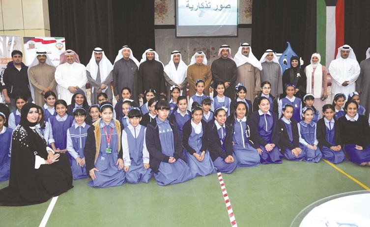 م.محمد بوشهري وم.خليفة الفريج يتوسطان ادارة وطلاب مدرسة الوسطى المتوسطة بنات خلال الزيارة- (زين علام) ﻿