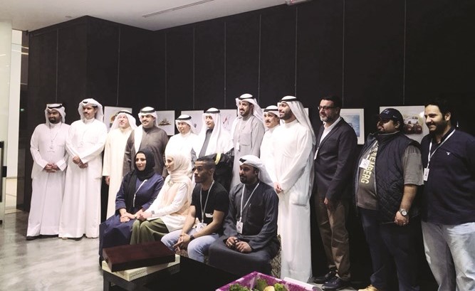 د. بدر الدويش والشيخ دعيج الخليفة يتوسطان الفنانين المشاركين في المعرض ﻿