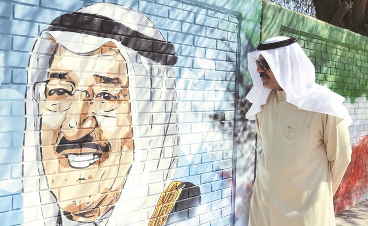الشيخ أحمد النواف أمام صورة لصاحب السمو الأمير الشيخ صباح الأحمد﻿
