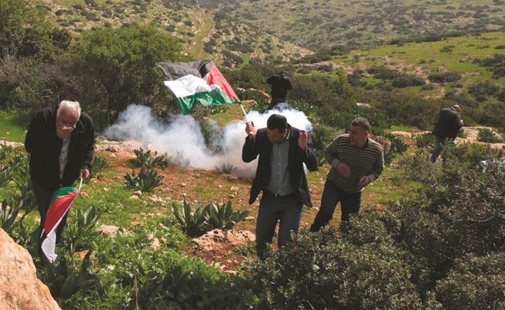 فلسطينيون يحتمون من الغاز المسيل للدموع خلال مواجهات مع الاحتلال على حدود غزة امس الاول	 (ا.ف.پ) ﻿