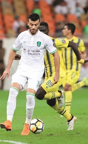 مهاجم الاهلي عمر السومة يروض الكرة أمام انظار مدافعي التعاون	(موقع الاهلي) ﻿