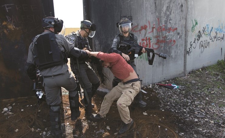 عناصر من قوات الاحتلال تعتقل فلسطينيا خلال مواجهات قرب رام الله امس الاول	(أ.پ) ﻿