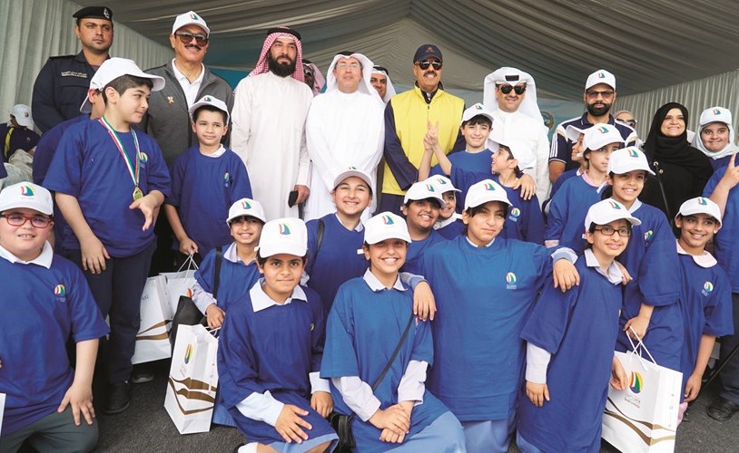 الشيخ أحمد النواف ووليد الخشتي يتوسطان الأطفال أثناء الفعالية﻿
