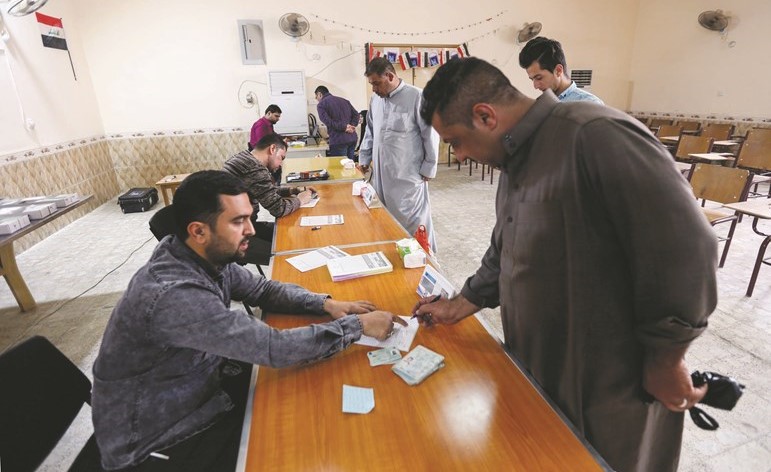 عراقيون يجددون بطاقاتهم الانتخابية في مدينة النجف امس -(أ.ف.پ)﻿