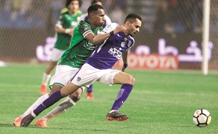 لاعب الهلال محمد البريك يتفادى مراقبة مدافع الاتفاق ﻿