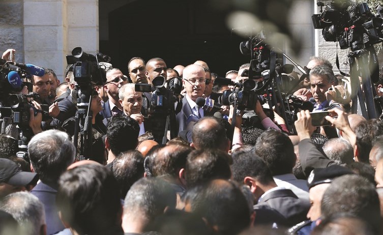 رئيس الحكومة الفلسطينية رامي الحمد الله محييا الحشود بعد عودته الى رام الله-(ا.ف.پ) ﻿
