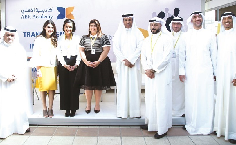 عميد كلية العلوم الإدارية د.مشاري الهاجري يتوسط موظفي البنك الأهلي الكويتي وإداريي جامعة الكويت﻿