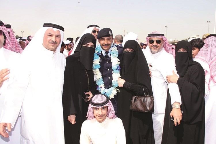 أحد الضباط الخريجين يتوسط اسرته احتفالا بالتخرج﻿