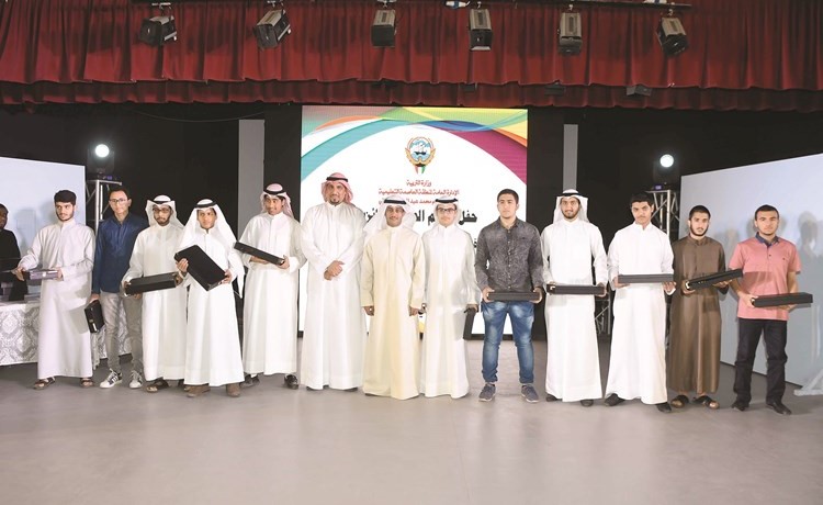 طلال جاسم الخرافي و جاسم الطراروة يتوسطان الطلاب الفائزين في المسابقة﻿