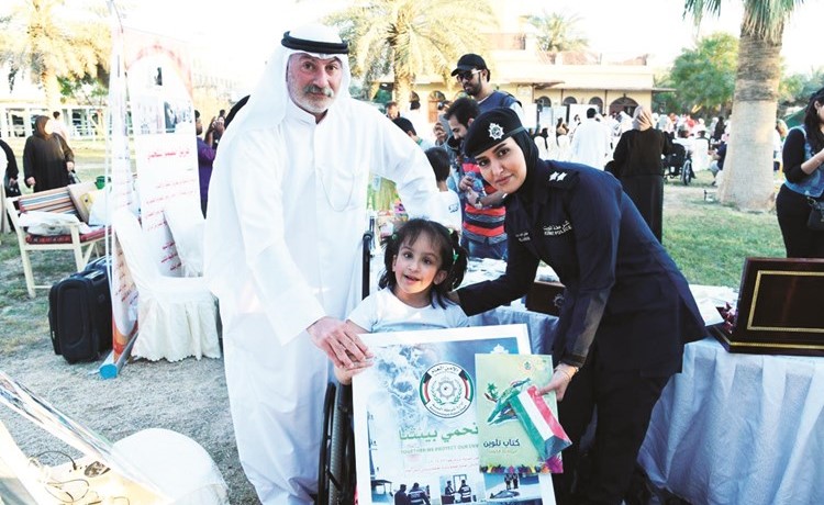 ضابطة من شرطة البيئة تقدم هدية الى طفلة خلال الفعالية﻿
