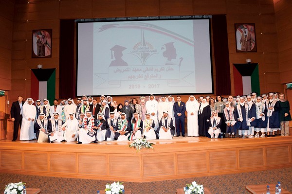 م.ناصر المهندي ود.وائل حمادة وفاطمة العازمي مع عدد من المتفوقين (متين غوزال)