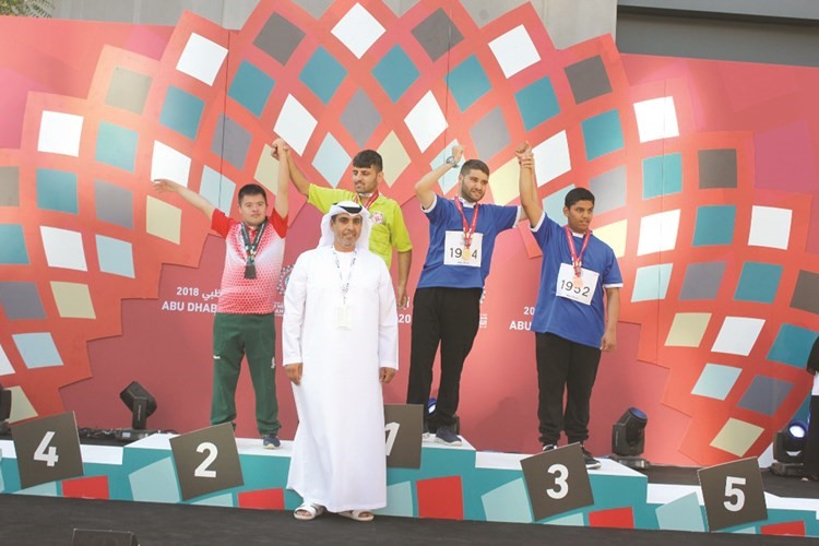 اللاعبان حسن سمير وعبدالله العلي أثناء التتويج في دورة الألعاب الإقليمية للألمبياد الخاص في أبوظبي﻿