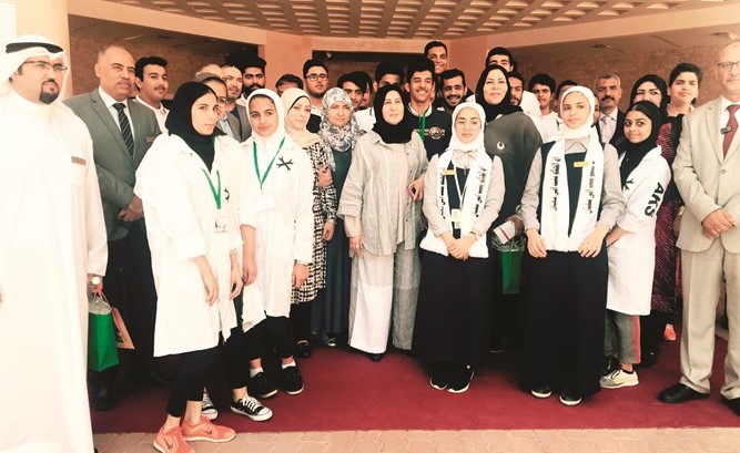 فاطمة الكندري مع عدد من المشاركات والمشاركين في المعرض﻿