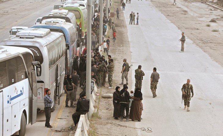 الحافلات التي أقلت المسلحين وأسرهم من الغوطة الشرقية باتجاه إدلب	(أ.ف.پ) ﻿