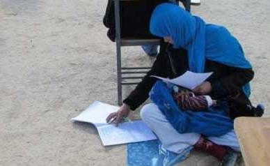 شاهد.. صورة سيدة تعتني بطفلها أثناء أداء اختبار قبول بجامعة تحظى بالأنتشار .. قصتها تستحق الإعجاب أكثر