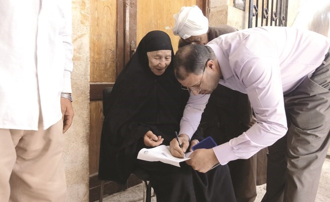 المستشار يساعد العجوز للإدلاء بصوتها﻿