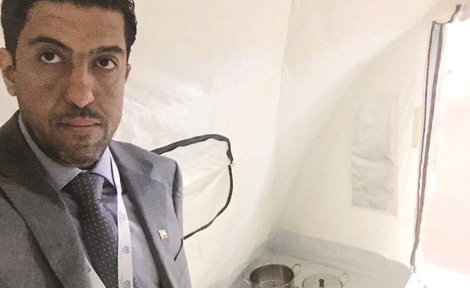 الزميل رشيد الفعم وخلفه متعلقات اللاجئين﻿