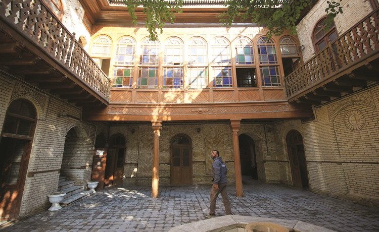 عراقي في فناء أحد المنازل العراقية القديمة ذات الشناشيل			(أ.ف.پ)﻿