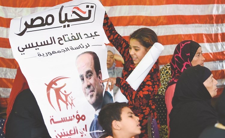 طفلة مصرية ترفع صورة الرئيس عبدالفتاح السيسي في إحدى اللجان﻿