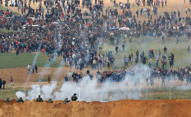فلسطينيون يواجهون رصاص قوات الاحتلال على حدود غزة في يوم الارض امس 	(أ.ف.پ)﻿